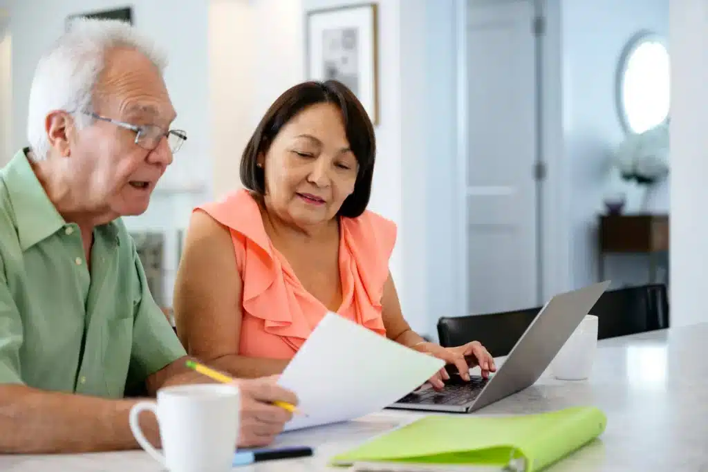 Senior couple sitting together and reviewing documents in a calm indoor setting.