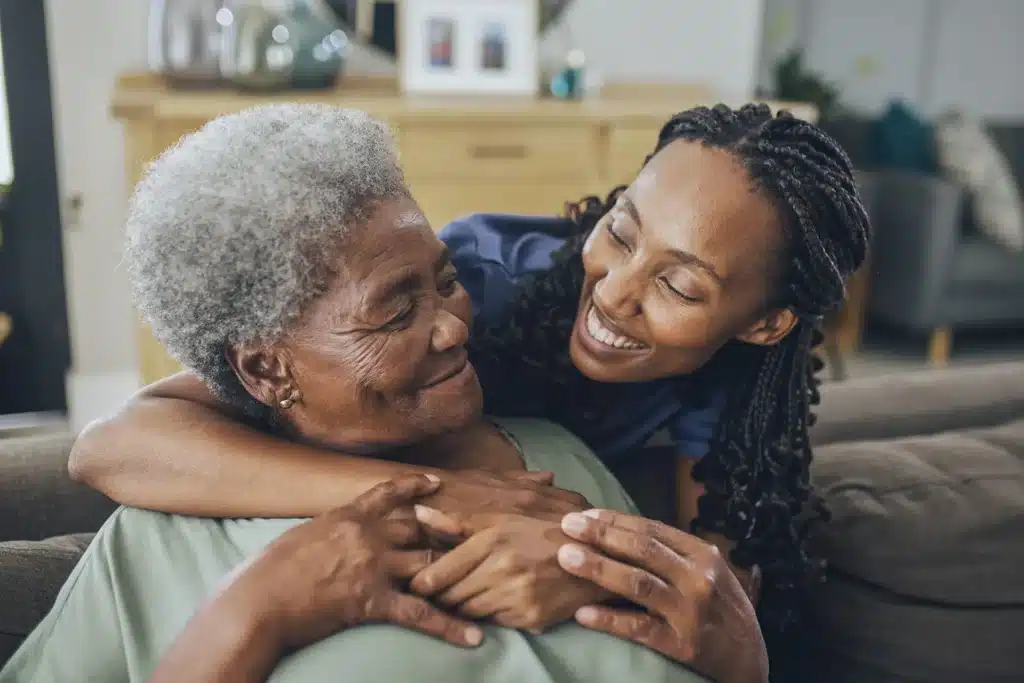 Senior women hugging caregiver smiling