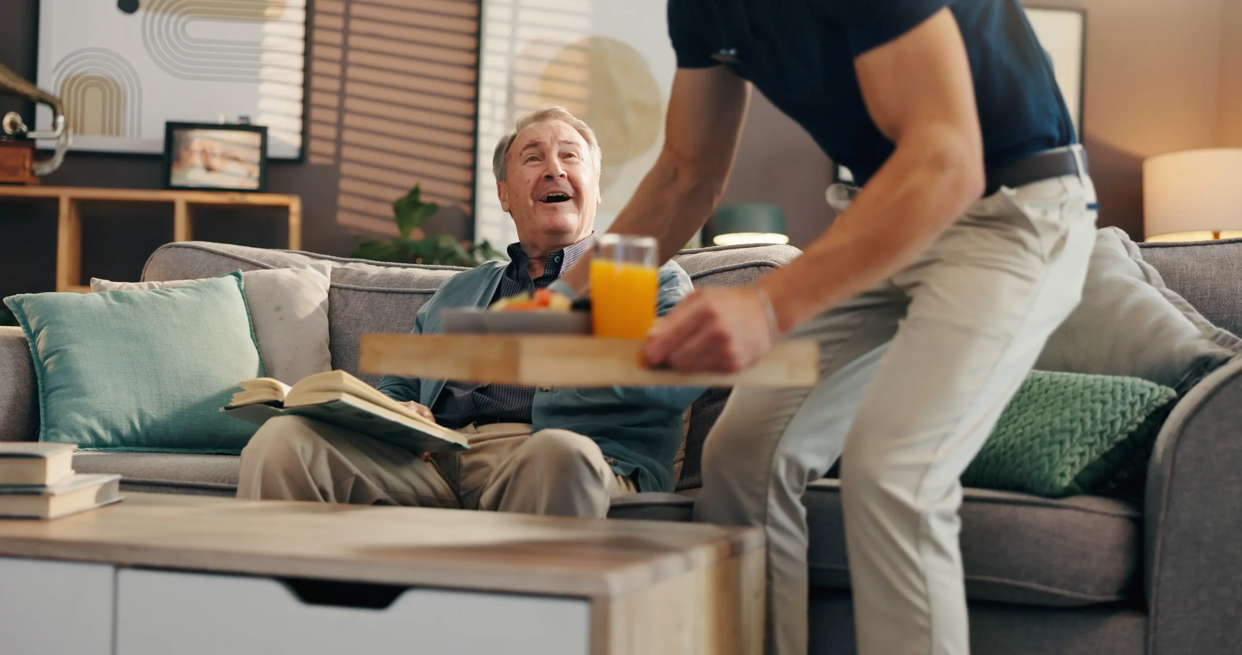 Caregiver assisting senior resident in living room at Franklin Johns Creek